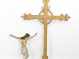 a statue of jesus standing next to a wooden cross