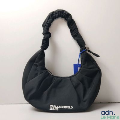 the black bag is sitting on a white surface with a blue tag attached to it