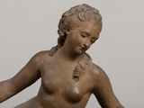 a statue of a woman sitting on a rock