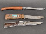 two knives and a knife sharper are on a table