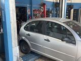 une voiture argentée posée sur un pont élévateur dans un garage