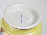 a yellow vase that has a tag on it