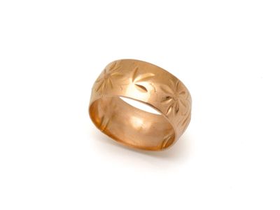 gros plan d'une bague en or sur fond blanc