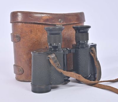 an old pair of binoculars sitting on top of a brown bag