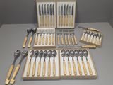 de nombreuses cuillères et fourchettes dans une boîte posée sur une table