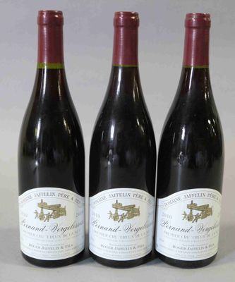 trois bouteilles de vin rouge sont alignées sur une table