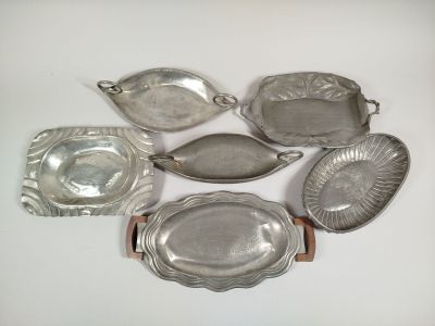 several silver dishes and trays on a white surface