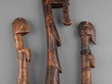 three pieces of wood carved to look like people