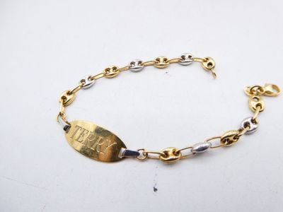 a close up of a gold bracelet with a tag on it