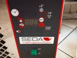 une machine rouge et noire posée sur un sol carrelé