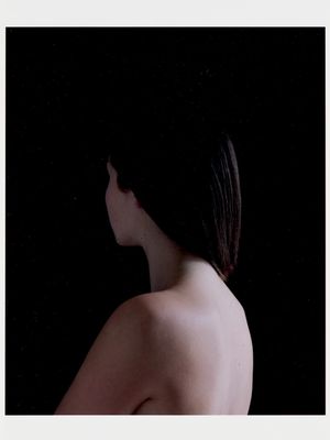 a woman that is standing in front of a black background