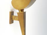 brass sconce wall light with a triangular shape on a white wall