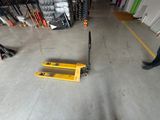 a man standing next to a forklift in a warehouse