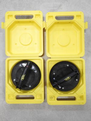 two yellow plastic boxes with black lids on a white surface