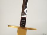 a knife on top of a gold stand with a plaque on top of it