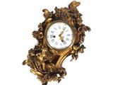 une horloge dorée sur un mur blanc, avec un fond blanc