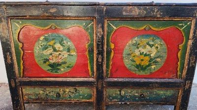 une vieille armoire en bois peinte en rouge et vert