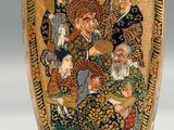 a gold vase with a picture of a group of people on it