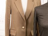 two jackets on a mannequin stand next to each other