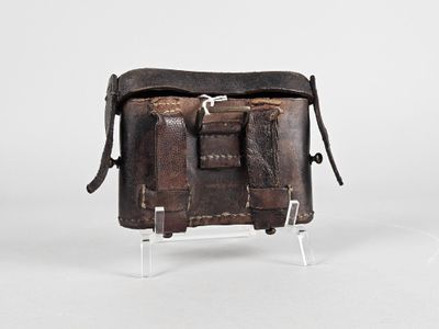 un vieux sac en cuir posé sur un support métallique