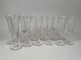 six verres à vin vides alignés sur une surface blanche