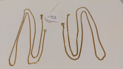 un ensemble de quatre colliers en or posés sur une surface blanche