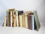 several books are stacked on top of each other on a white surface