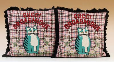 two pillows with cats on them sitting on top of a table