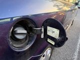 a purple car with a gas pump attached to it ' s hood