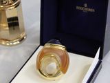 an image of a ring in a box next to a bottle of perfume