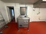 une photo d'une cuisine avec un sol rouge et des appareils électroménagers en inox