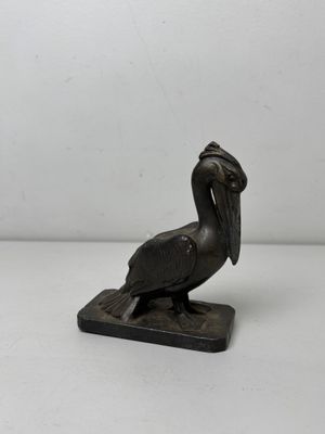 bronze statue of a pelican on a marble base