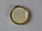 an image of a close up of a small pendant on a table