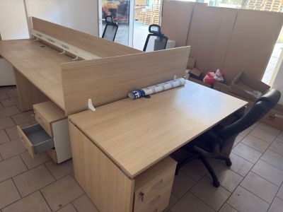 a wooden desk with a black chair in the corner of the room