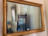 a mirror hanging on the wall next to a vase
