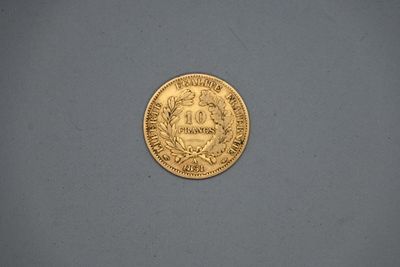 gros plan d'une pièce d'or sur une surface grise
