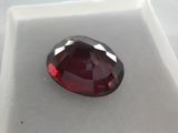 a close up of a red diamond on a white surface