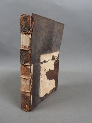 Un vieux livre est posé sur une table devant un fond gris