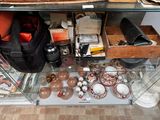 une étagère en verre sur laquelle sont posés de nombreux objets, dans une pièce