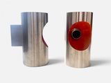 two silver vases with red knobs on them