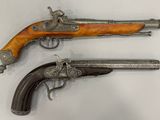 deux vieux pistolets avec des crosses en bois et des poignées en argent