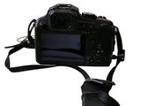 a black camera with a strap attached to it ' s body