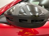 a close up of a helmet on the hood of a red car
