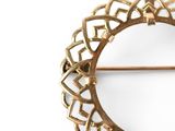 a gold brooch with a circular design on it