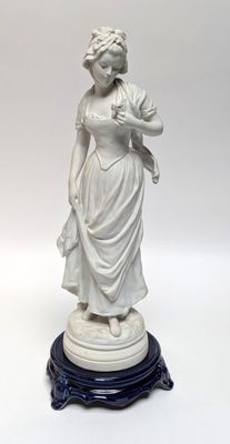 statue of a woman holding a basket of flowers on a pedestal