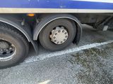 a blue and white semi truck parked in a parking lot