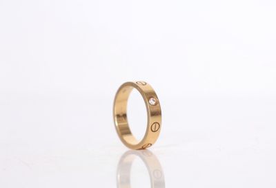 a close up of a gold ring on a white surface