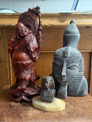 a statue of a man holding a staff next to a statue of a woman