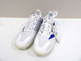 une paire de baskets blanches et bleues posées sur une table blanche