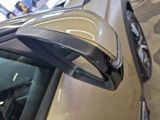 a close up of a car ' s side mirror with a car in the background